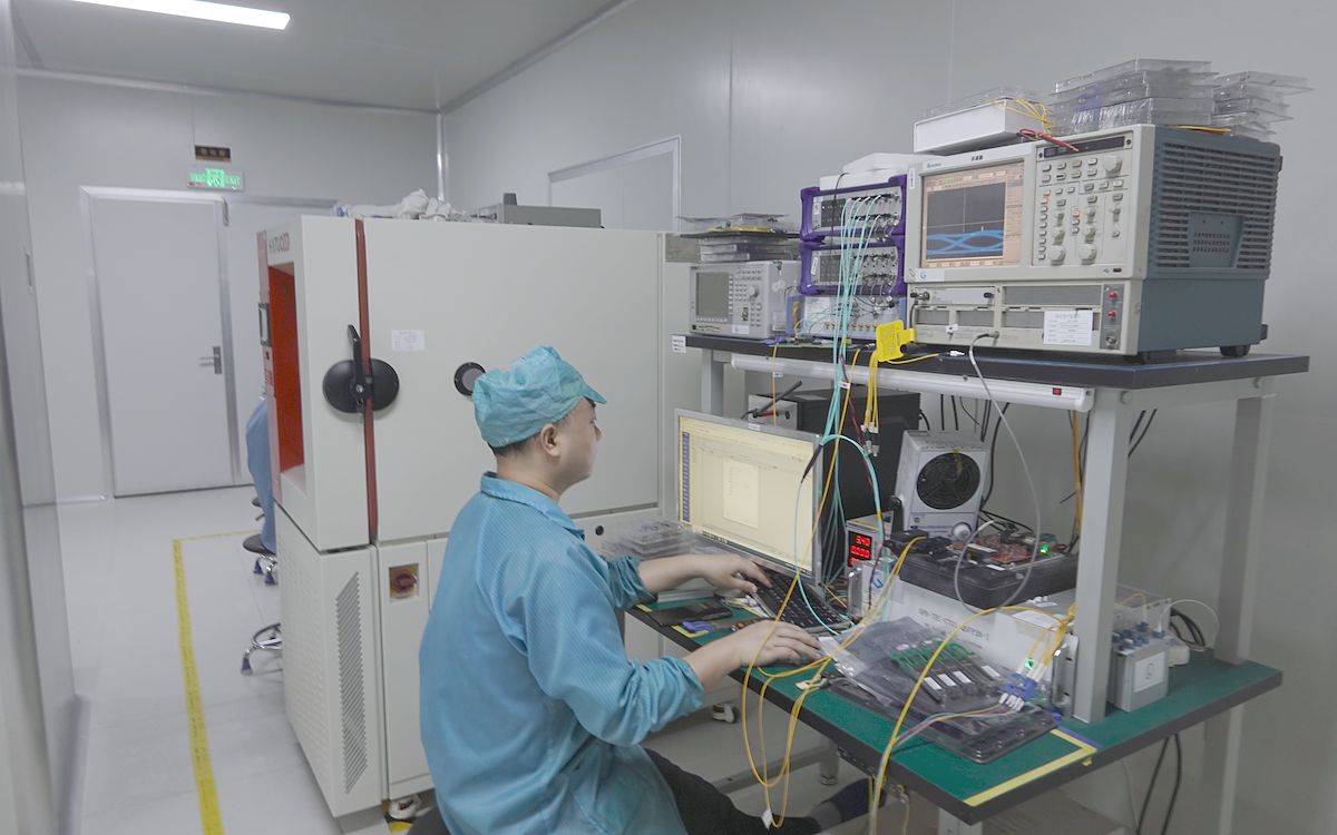 Engineer running transceiver tests beside a temperature chamber